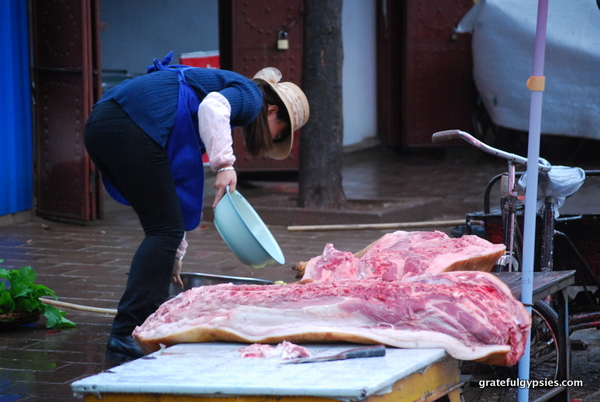 一个屠夫正在展示刚切好的猪片。