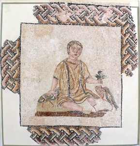 来自罗马葬礼纪念碑的马赛克，描绘了一个小男孩坐着，上面有固定的釉；他的右手握着一个ridge，左手一堆葡萄，鹅口疮啄着他们。从三世纪开始索斯陵墓。由Wikicommons和Ad Meskens提供。